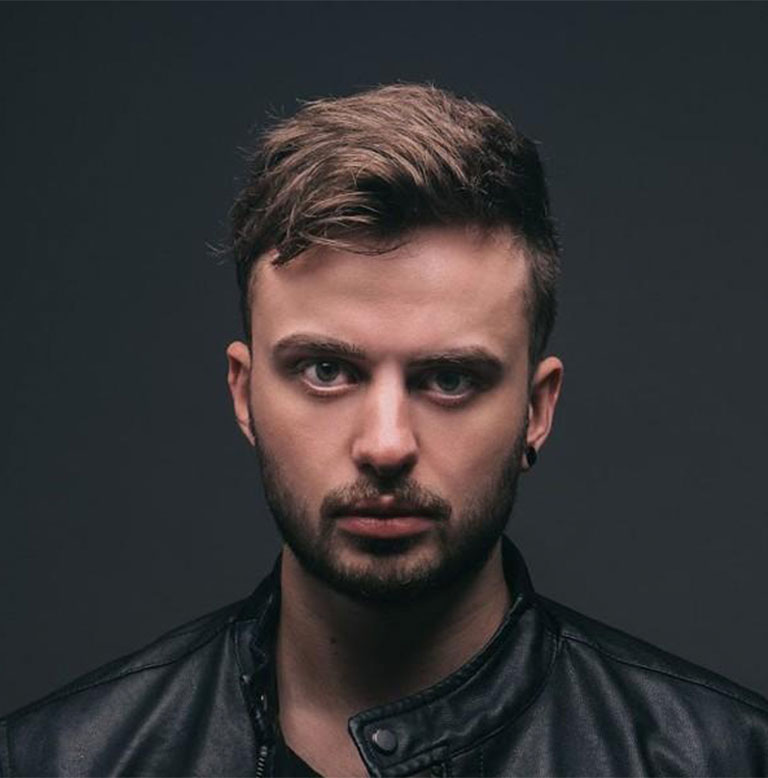 Porträt eines Mannes mit kurzen Haaren und Bart, der eine schwarze Lederjacke trägt.