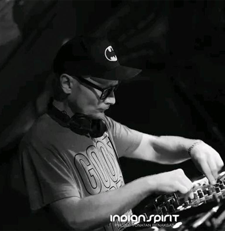 Zilla in Dub mit einer schwarzen Mütze und Brille, während er an einem DJ-Pult arbeitet.