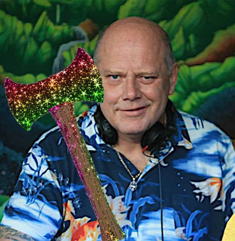 Mann mit glitzernder Axt und Hawaiianischem Hemd, lächelt in die Kamera.