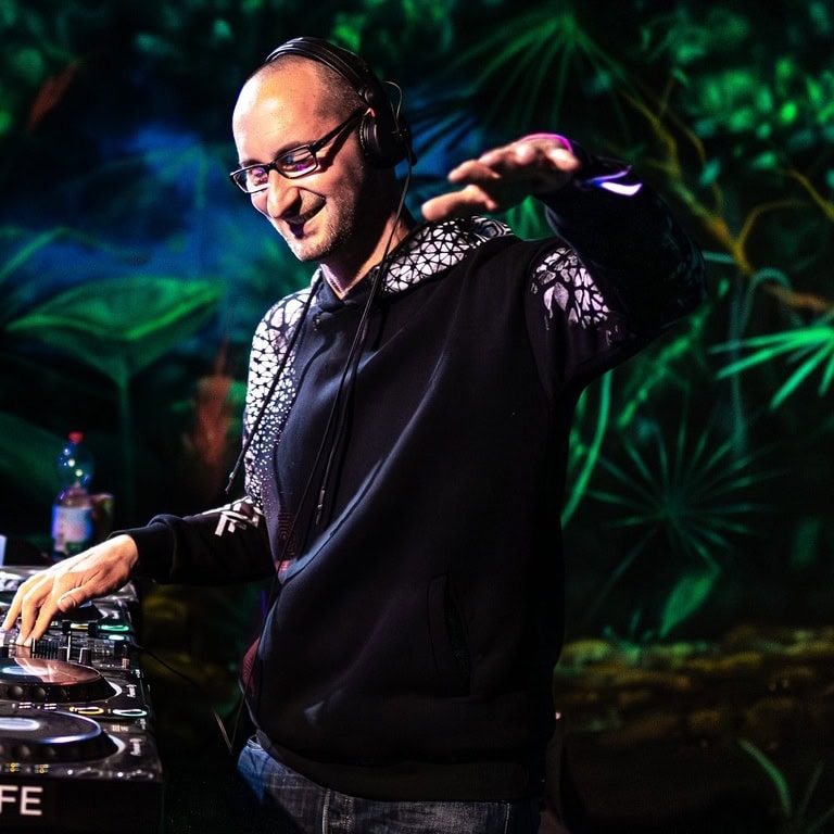 DJ, der an einem Mischpult arbeitet, während er Musik auflegt, mit Kopfhörern und lässiger Kleidung.