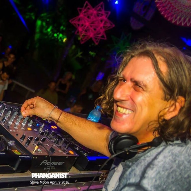 DJ, der an einem Mischpult arbeitet, während er auf einer Veranstaltung auftritt. Lächelnd und konzentriert auf die Musik.